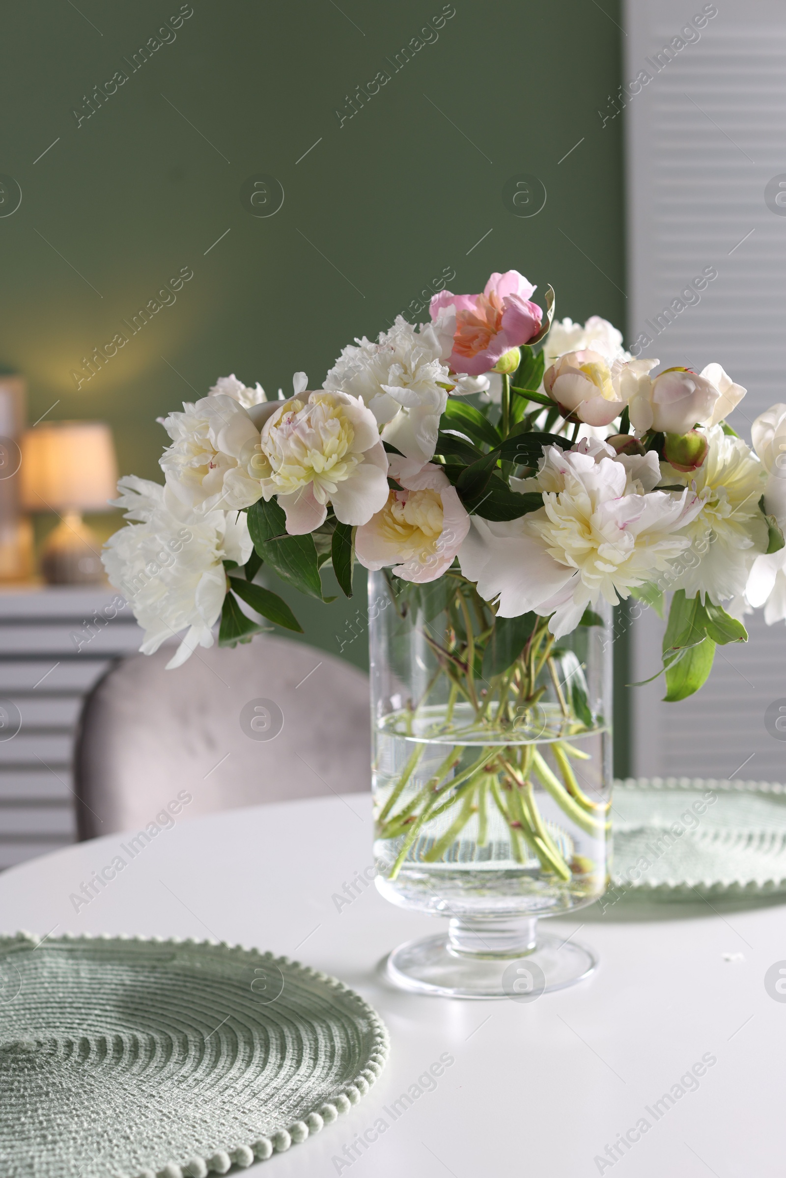 Beautiful table setting with vase of flowers in dining room Photo of Beautiful table setting with vase of flowers in dining room