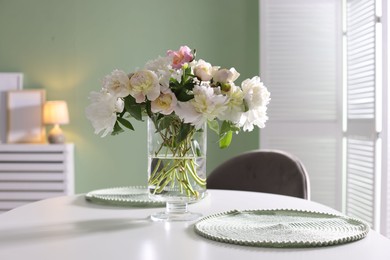 Photo of Beautiful table setting with vase of flowers in dining room