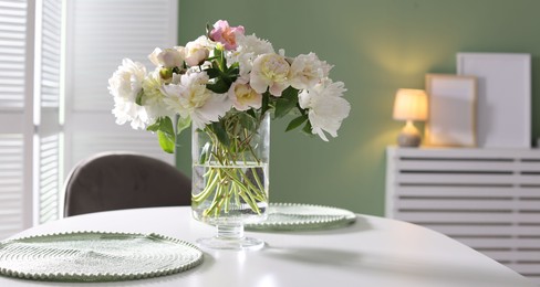 Photo of Beautiful table setting with vase of flowers in dining room, space for text