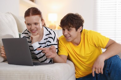 Photo of Teenage students with laptop studying at home