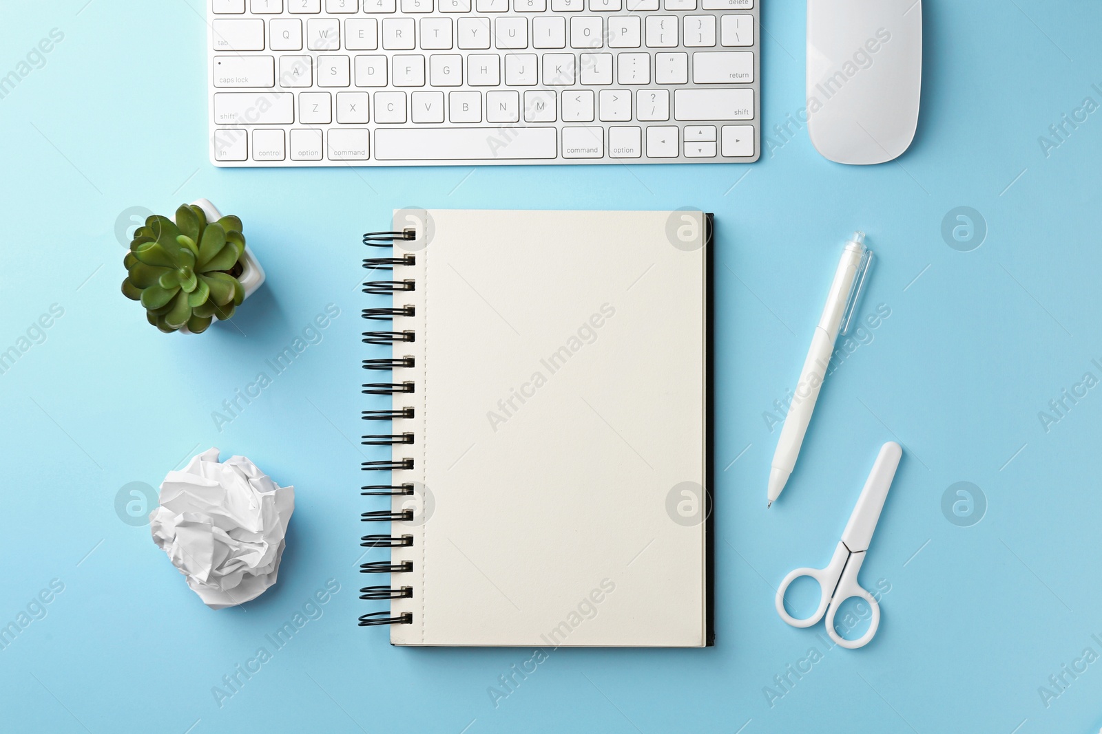 Notebook, other stationery, floral decor, computer keyboard and mouse on light blue background, flat lay Photo of Notebook, other stationery, floral decor, computer keyboard and mouse on light blue background, flat lay