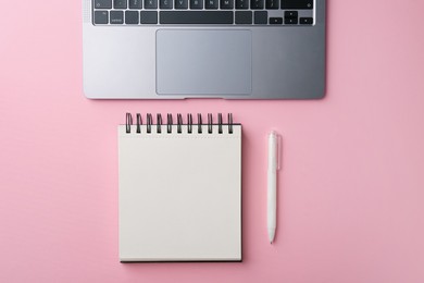 Photo of Notebook, pen and laptop on pink background, flat lay