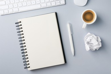 Photo of Notebook, pen, crumpled paper, coffee, computer keyboard and mouse on grey background, flat lay