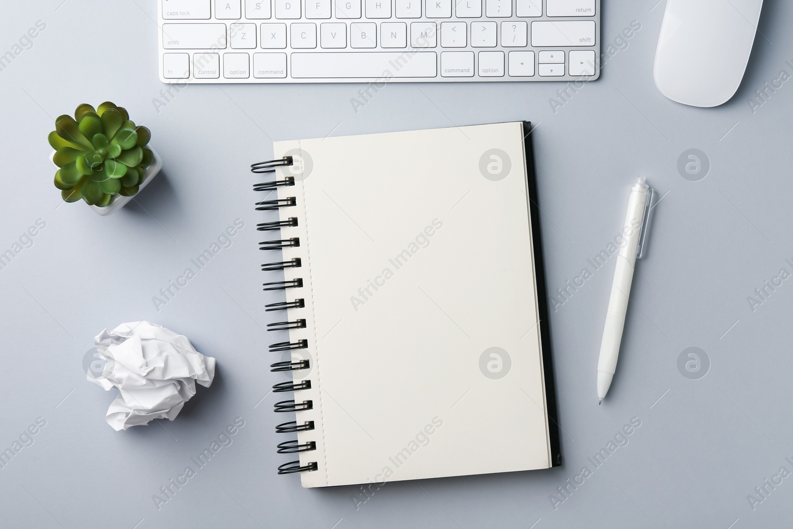 Photo of Notebook, pen, crumpled paper, floral decor, computer keyboard and mouse on grey background, flat lay