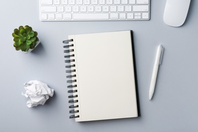 Photo of Notebook, pen, crumpled paper, floral decor, computer keyboard and mouse on grey background, flat lay