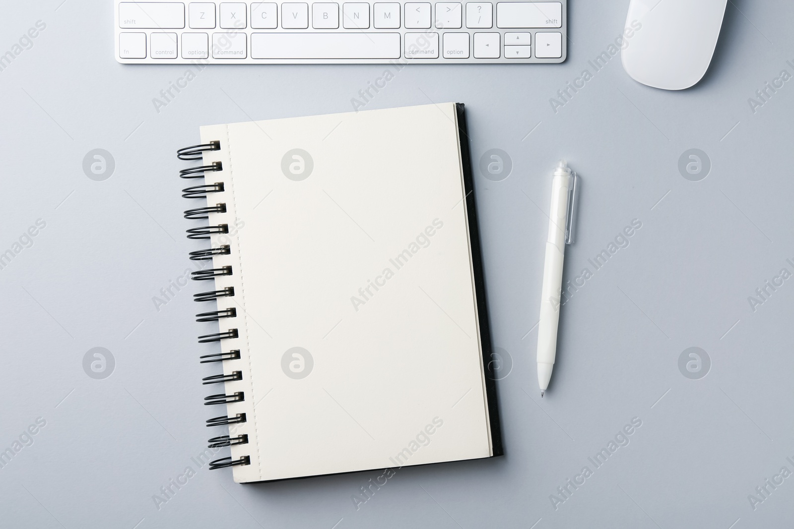Notebook, pen, computer keyboard and mouse on grey background, flat lay Photo of Notebook, pen, computer keyboard and mouse on grey background, flat lay