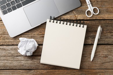 Photo of Notebook, other stationery and laptop on wooden table, flat lay