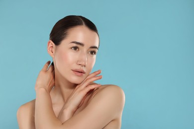 Photo of Beautiful woman after spa treatment on light blue background. Space for text