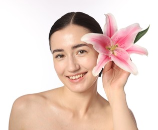 Photo of Portrait of smiling woman with lily flower after spa treatment on white background, closeup