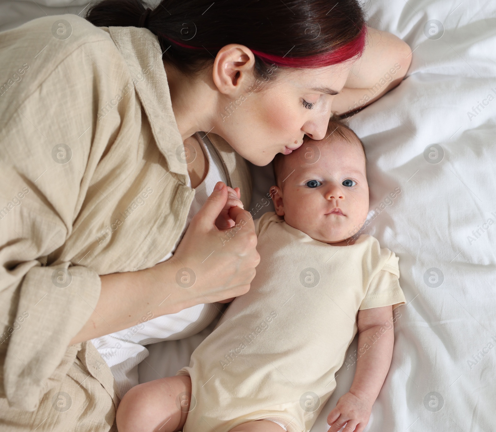 Mother with her newborn baby on bed indoors, top view Photo of Mother with her newborn baby on bed indoors, top view