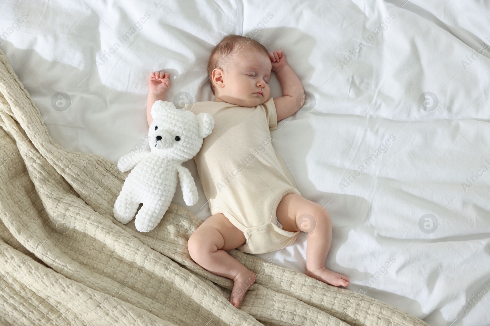 Photo of Cute newborn baby sleeping on bed indoors, top view