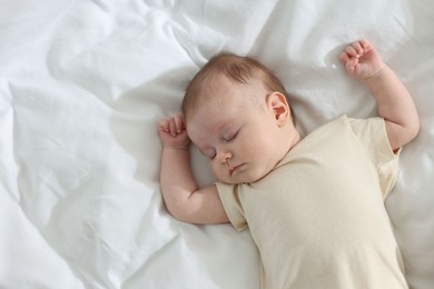 Photo of Cute newborn baby sleeping on bed indoors, top view. Space for text