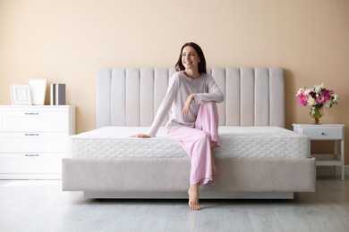 Photo of Woman on bed with orthopedic mattress at home