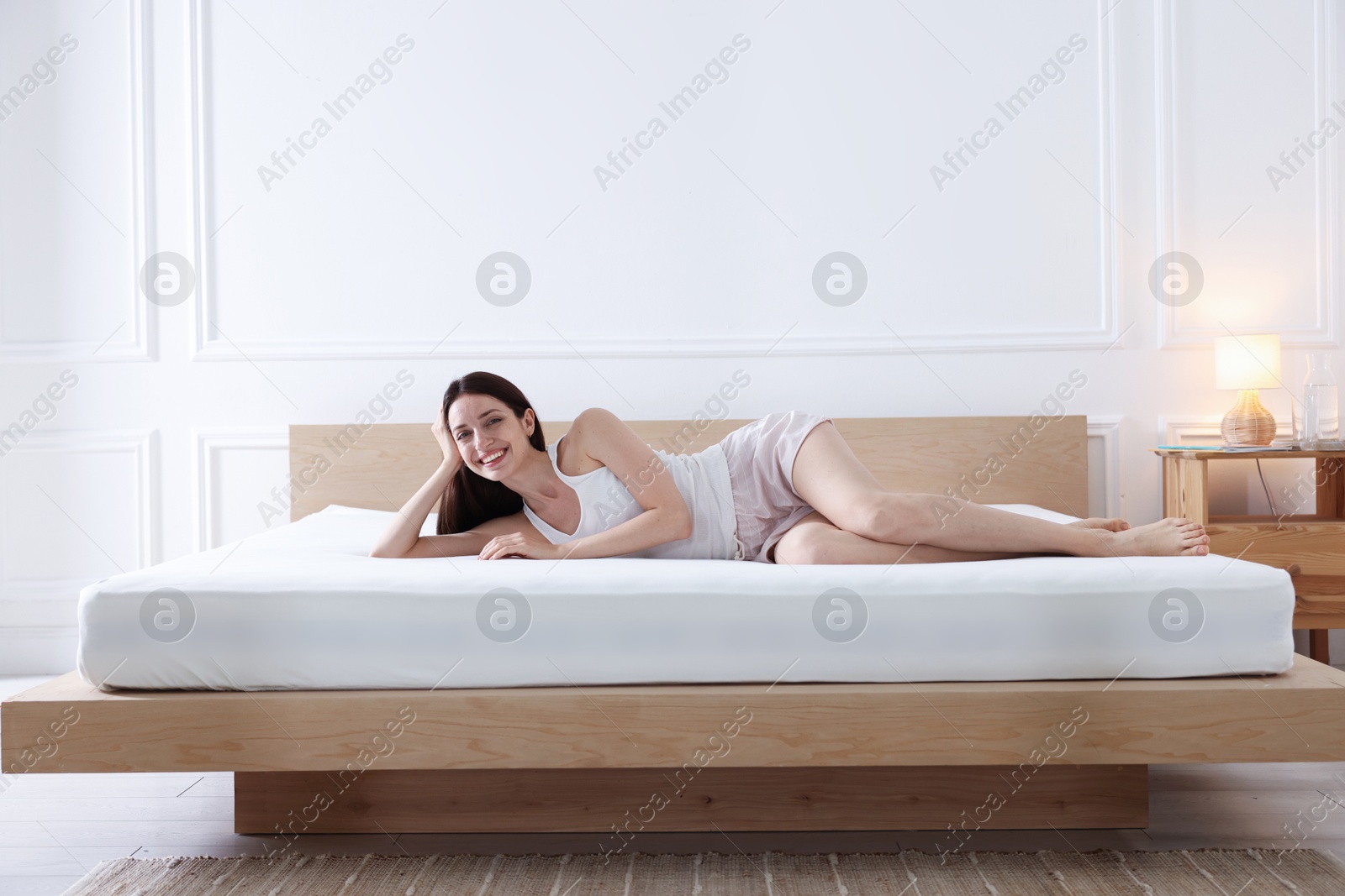 Woman lying on bed with orthopedic mattress at home Photo of Woman lying on bed with orthopedic mattress at home