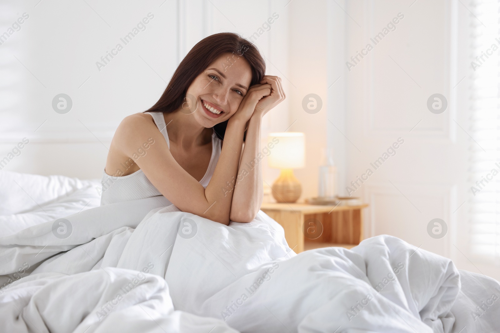 Woman on bed with soft mattress at home Photo of Woman on bed with soft mattress at home