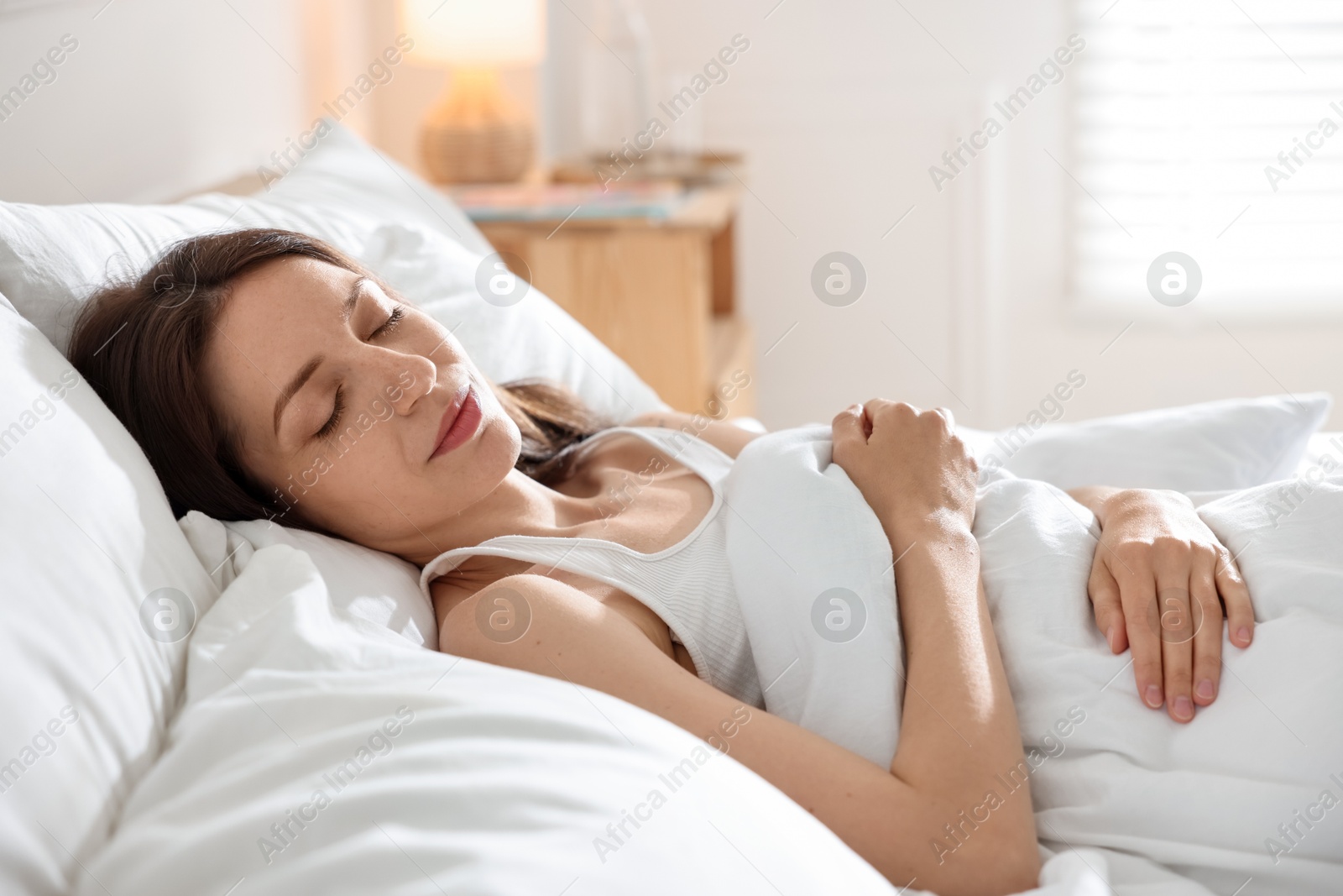 Woman sleeping on bed with soft mattress at home Photo of Woman sleeping on bed with soft mattress at home