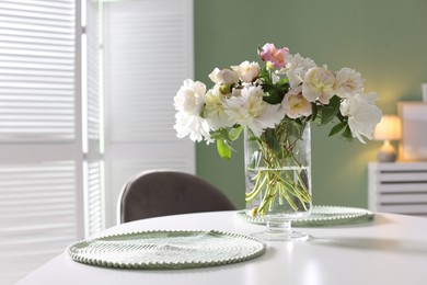 Photo of Beautiful table setting with vase of flowers in dining room