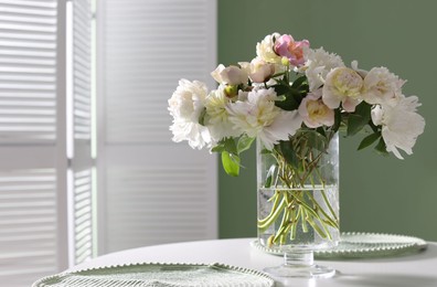 Photo of Beautiful table setting with vase of flowers in dining room, space for text
