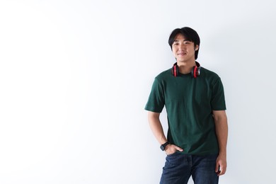 Photo of Confident Asian man with headphones on white background. Space for text