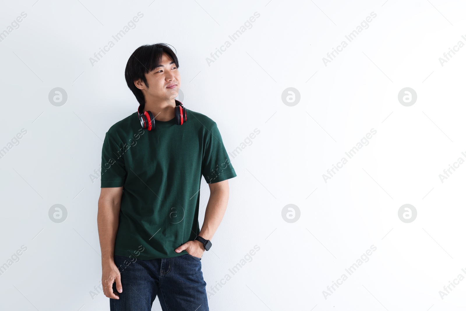 Confident Asian man with headphones on white background. Space for text Photo of Confident Asian man with headphones on white background. Space for text