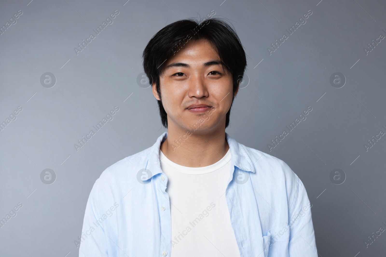 Portrait of handsome Asian man on grey background Photo of Portrait of handsome Asian man on grey background
