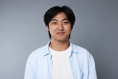 Photo of Portrait of handsome Asian man on grey background