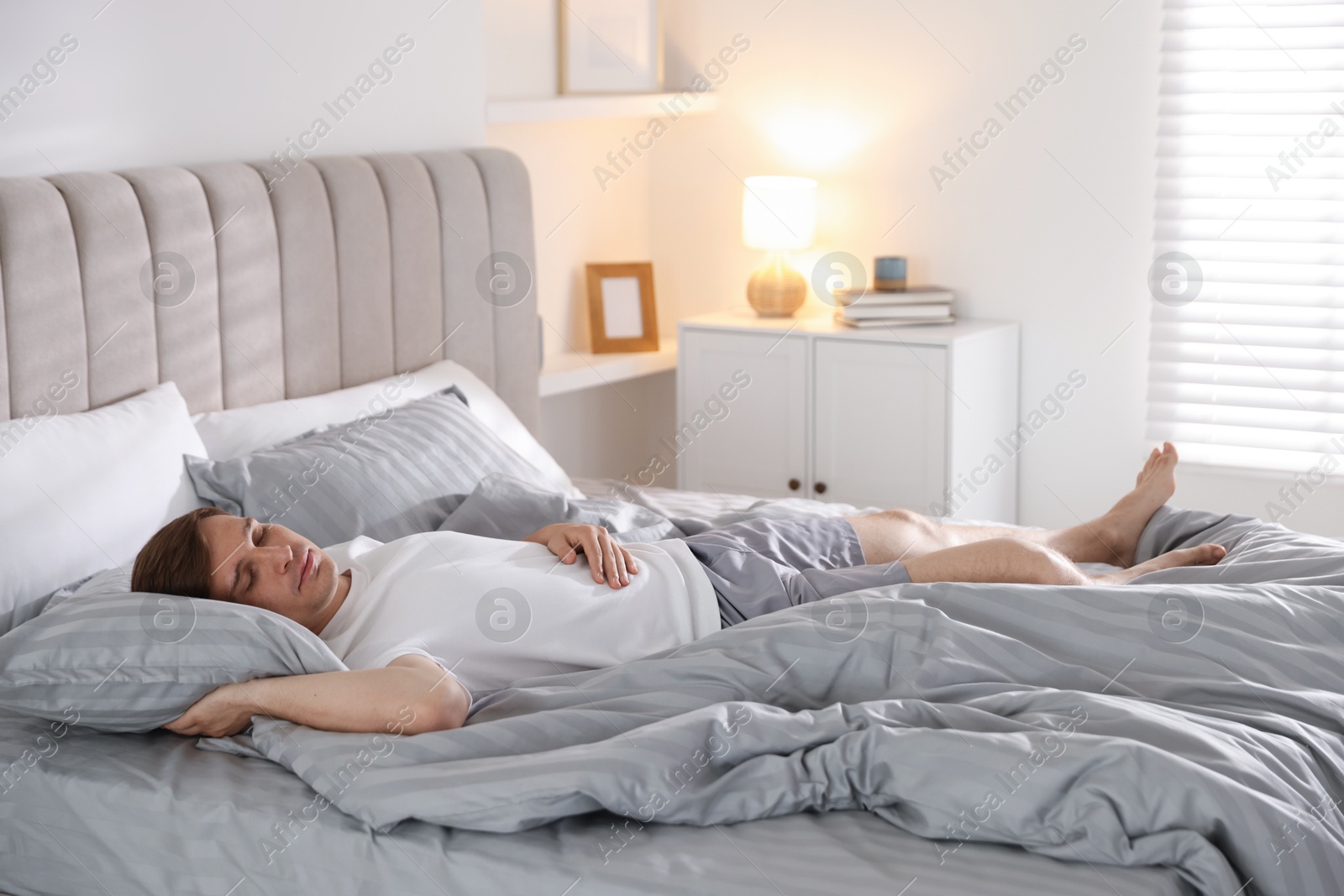 Young man sleeping on bed with soft mattress at home Photo of Young man sleeping on bed with soft mattress at home