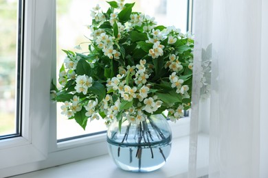 Photo of Beautiful jasmine flowers in vase near window indoors