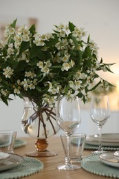 Photo of Bouquet of beautiful jasmine flowers on dining table indoors