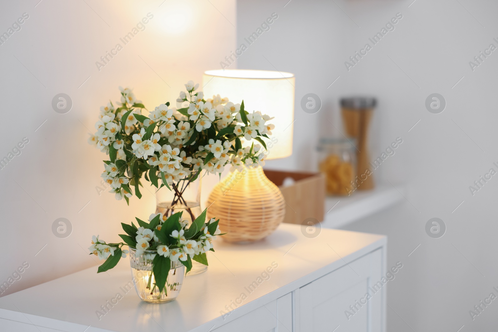 Bouquet of beautiful jasmine flowers in vase on white table indoors. Space for text Photo of Bouquet of beautiful jasmine flowers in vase on white table indoors. Space for text