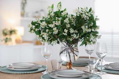 Photo of Bouquet of beautiful jasmine flowers on dining table indoors