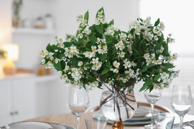 Photo of Bouquet of beautiful jasmine flowers on dining table indoors
