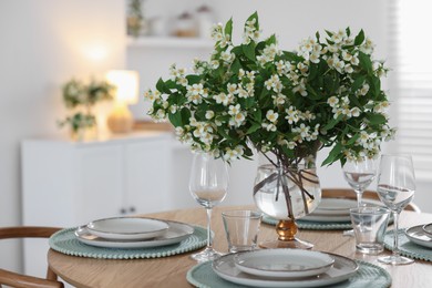Photo of Bouquet of beautiful jasmine flowers on dining table indoors