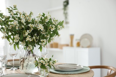 Photo of Bouquet of beautiful jasmine flowers on dining table indoors. Space for text