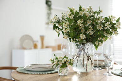 Photo of Bouquet of beautiful jasmine flowers on dining table indoors. Space for text