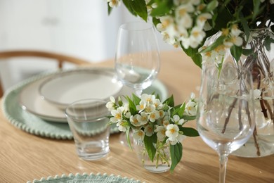 Photo of Bouquet of beautiful jasmine flowers on dining table indoors, closeup