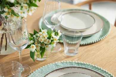 Photo of Beautiful jasmine flowers on dining table indoors, closeup