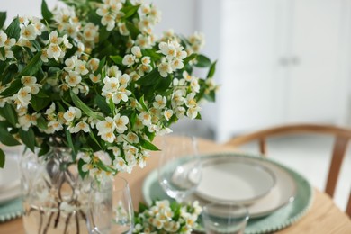 Photo of Bouquet of beautiful jasmine flowers on dining table indoors, closeup. Space for text