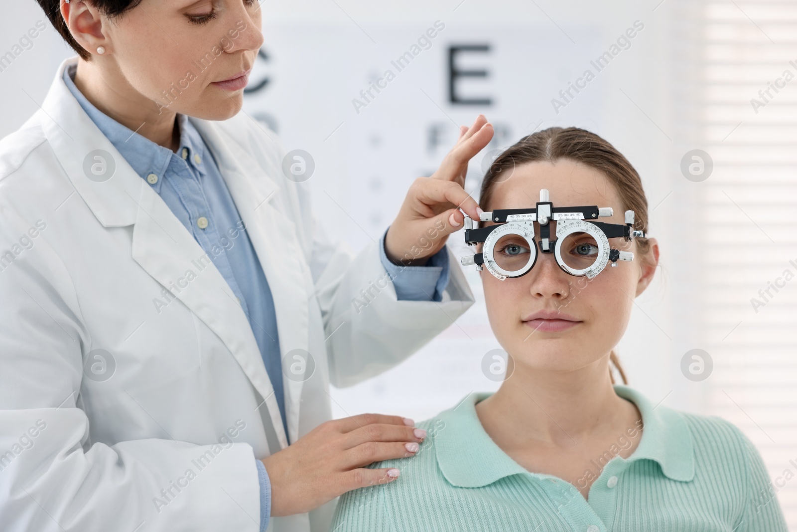 Ophthalmologist examining patient's vision with trial frame in clinic Photo of Ophthalmologist examining patient's vision with trial frame in clinic