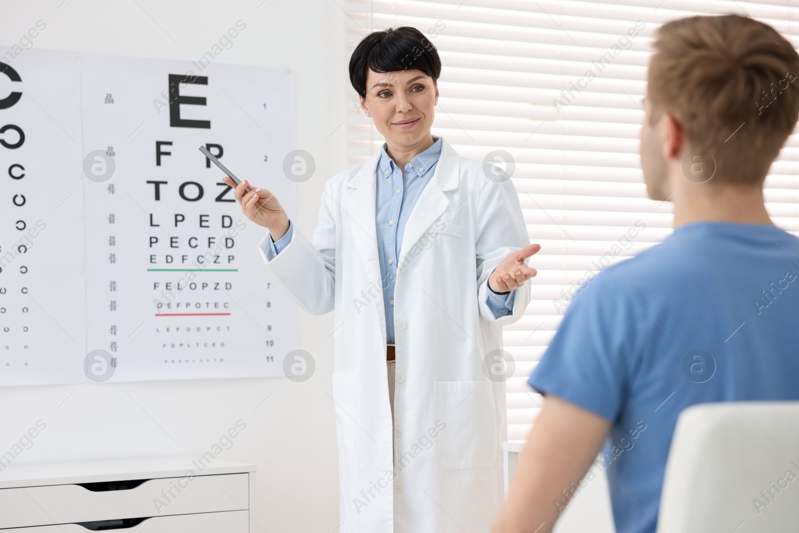 Professional ophthalmologist examining patient's vision in clinic Photo of Professional ophthalmologist examining patient's vision in clinic