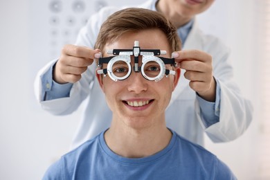 Photo of Ophthalmologist examining patient's vision with trial frame in clinic, closeup