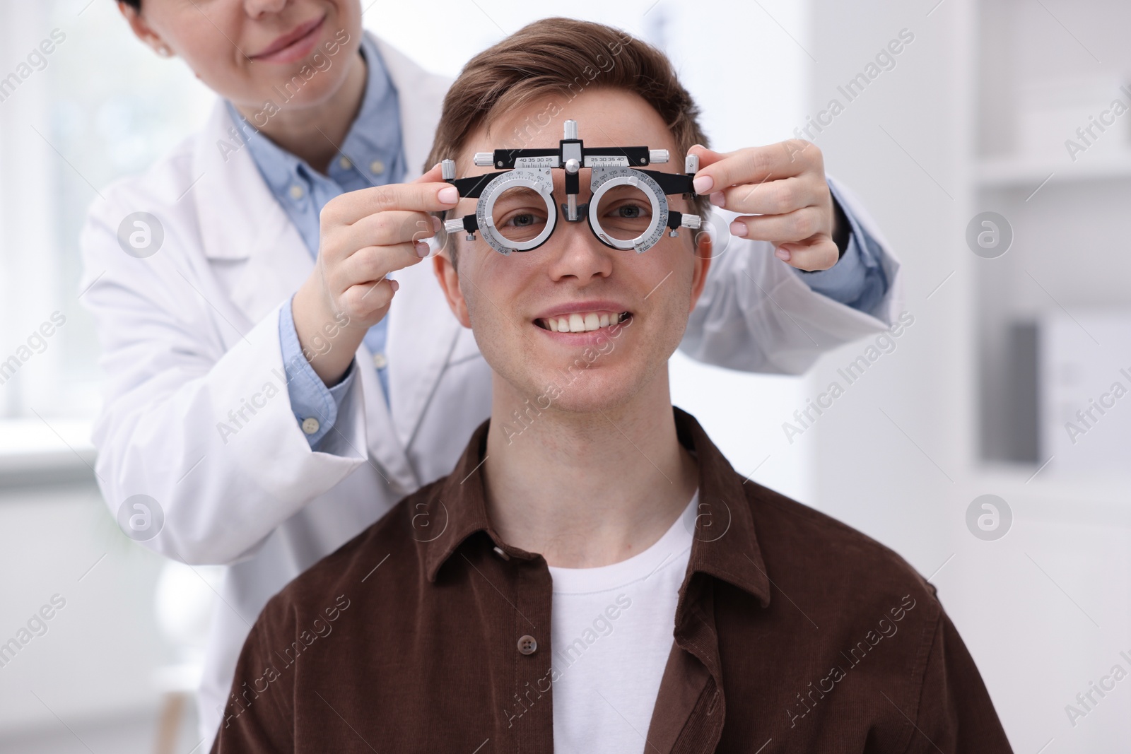Ophthalmologist examining patient's vision with trial frame in clinic, closeup Photo of Ophthalmologist examining patient's vision with trial frame in clinic, closeup
