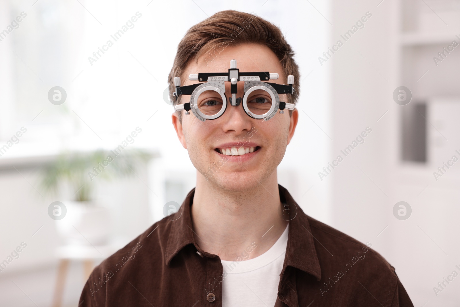 Young man with trial frame in ophthalmology clinic Photo of Young man with trial frame in ophthalmology clinic