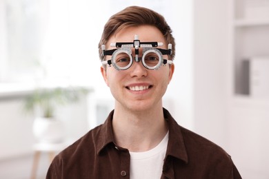 Photo of Young man with trial frame in ophthalmology clinic