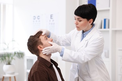 Photo of Professional ophthalmologist examining patient's vision in clinic