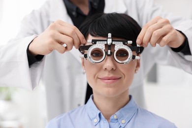 Photo of Ophthalmologist examining patient's vision with trial frame in clinic, closeup