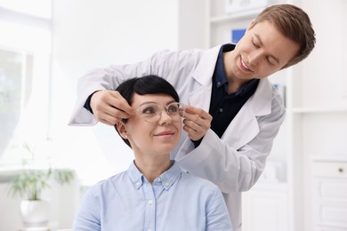 Photo of Ophthalmologist giving glasses to patient in clinic