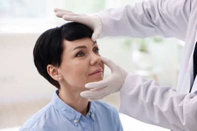 Photo of Professional ophthalmologist examining patient's vision in clinic, closeup