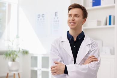 Photo of Portrait of professional ophthalmologist with crossed arms in clinic