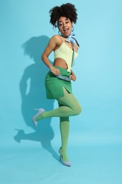 Photo of Fashionable portrait of beautiful Brazilian woman in stylish outfit on light blue background